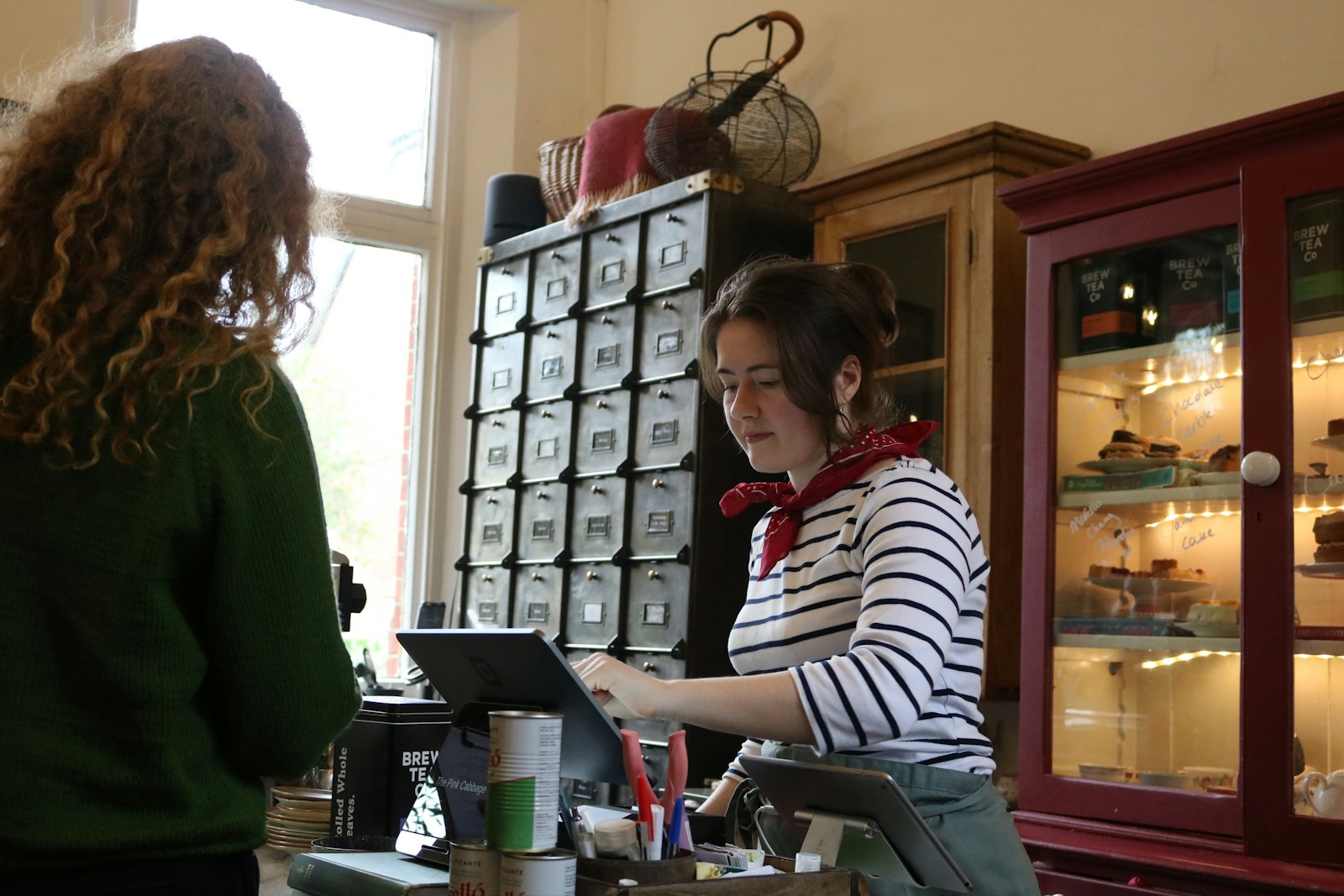 Medewerker aan de kassa achter de toonbank van een café