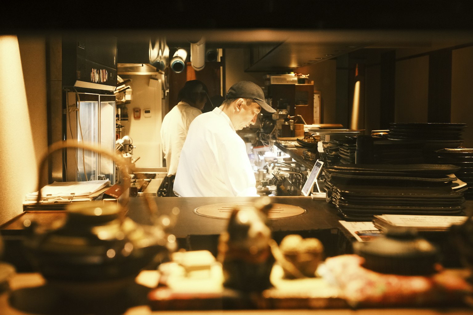 Koks aan het werk in een restaurantkeuken, met een tablet op de uitgifte